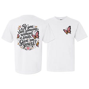 May include: A white short-sleeve t-shirt featuring a small pink and orange butterfly on the front chest. The back displays the text "If you see someone without a smile, Give 'em yours!" surrounded by butterflies, a pink heart, and small stars.