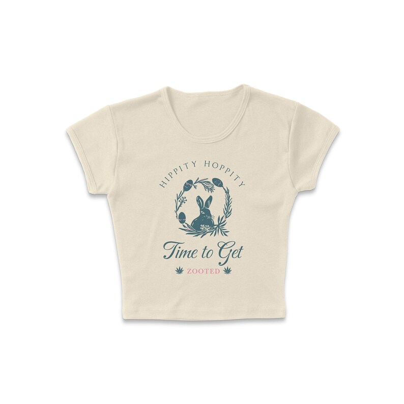 May include: A cream-colored cropped t-shirt with a graphic of a rabbit in a wreath with the text "Hippity Hoppity Time to Get Zooted".