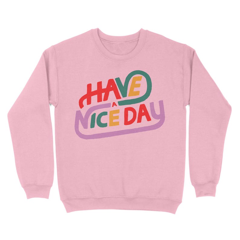 May include: Pink sweatshirt with the text "HAVE A NICE DAY" in a colourful, retro font.