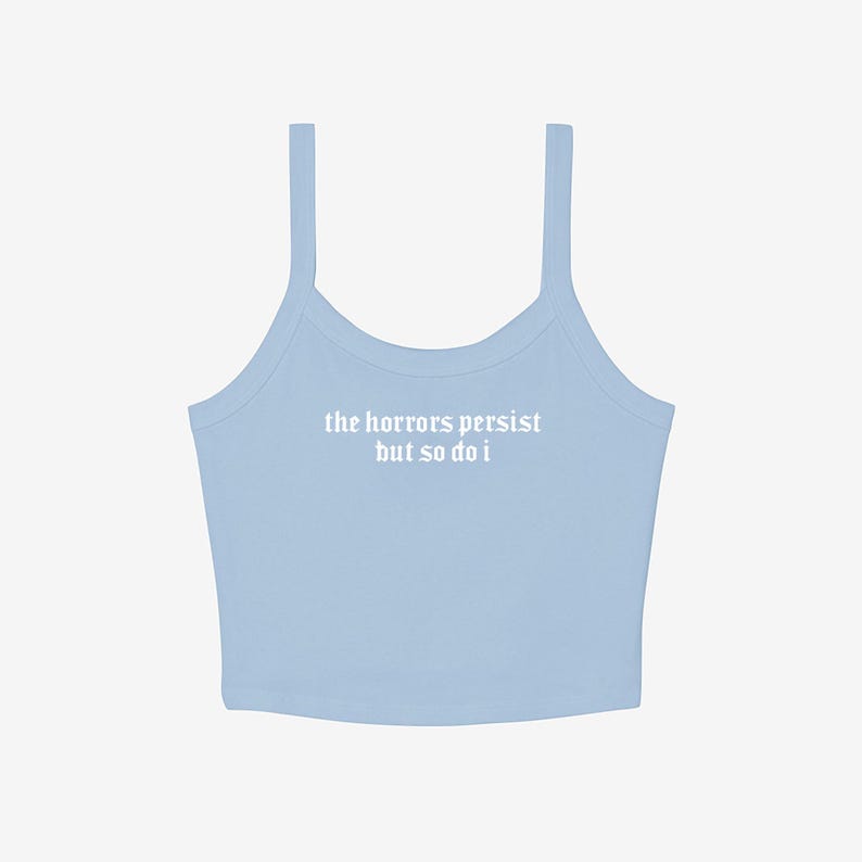 May include: A light blue camisole top with thin straps. The text "the horrors persist but so do i" is printed in white across the front. The top is made of a soft, ribbed material.
