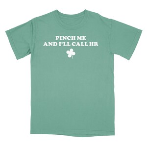 Peut inclure: Un t-shirt vert turquoise avec un tr&egrave;fle blanc et le texte "Pinch me and I'll call HR".