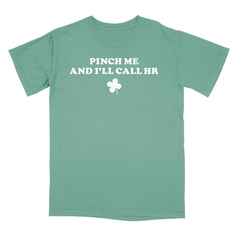 Peut inclure: Un t-shirt vert turquoise avec un tr&egrave;fle blanc et le texte "Pinch me and I'll call HR".