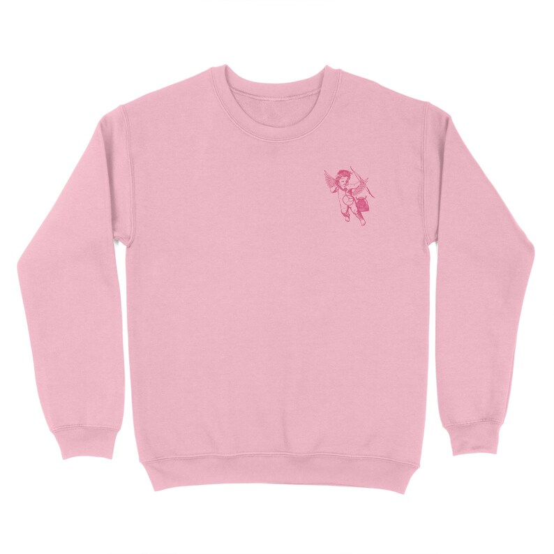 May include: A pink sweatshirt with a small embroidered image of a cherub holding a bow and arrow.