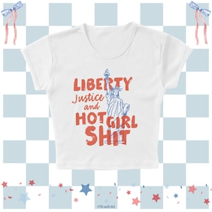 May include: White crop top with the text "LIBERTY Justice and HOT GIRL SHIT" in red and blue. The Statue of Liberty is featured in the design. The top is set against a patriotic background with bows and stars.