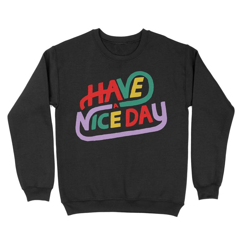 May include: Black sweatshirt with a colourful graphic that says "HAVE A NICE DAY" in a retro font.