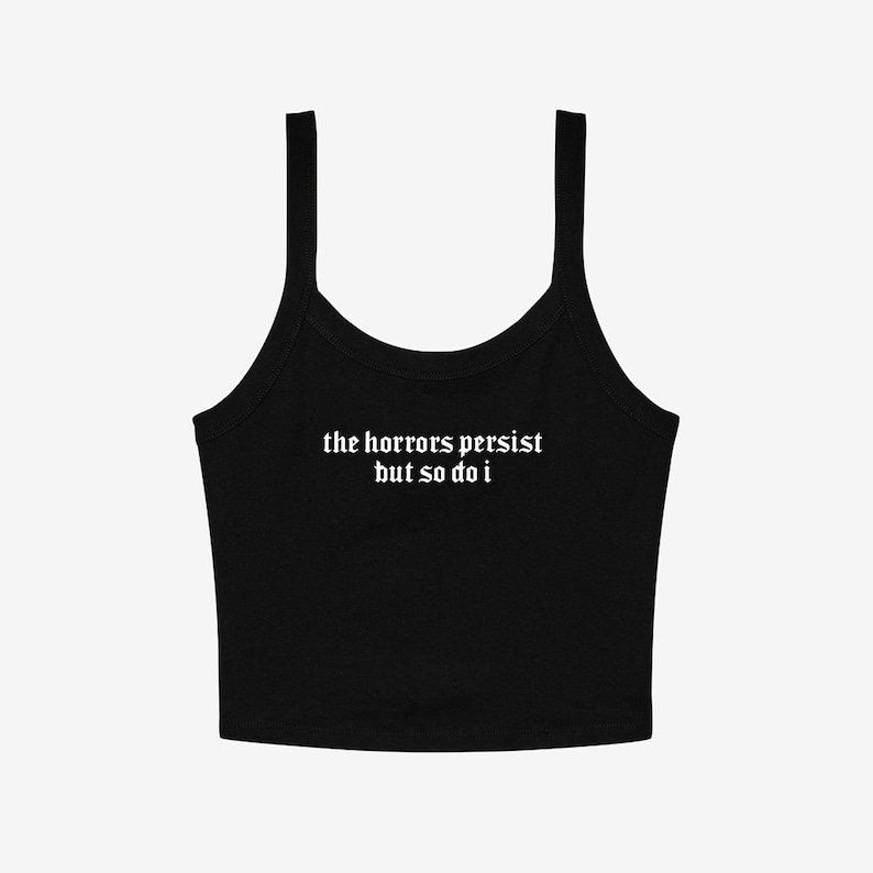 May include: Black tank top with thin straps. The white text on the front reads "the horrors persist but so do i". The top is a solid color and has a scoop neckline.