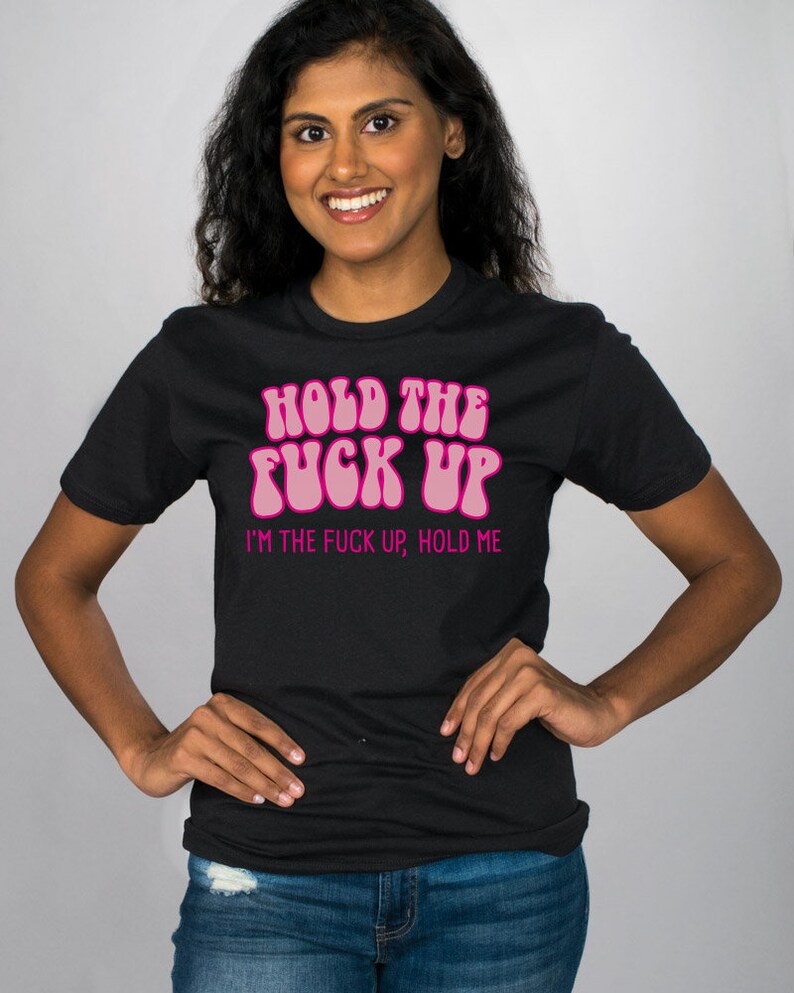 May include: Black t-shirt with pink text that reads "Hold the Fuck Up, I'm the Fuck Up, Hold Me."
