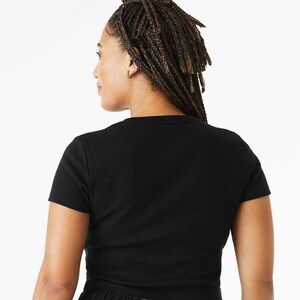 May include: A black cropped t-shirt with short sleeves. The shirt is made of a soft, stretchy fabric and has a relaxed fit.
