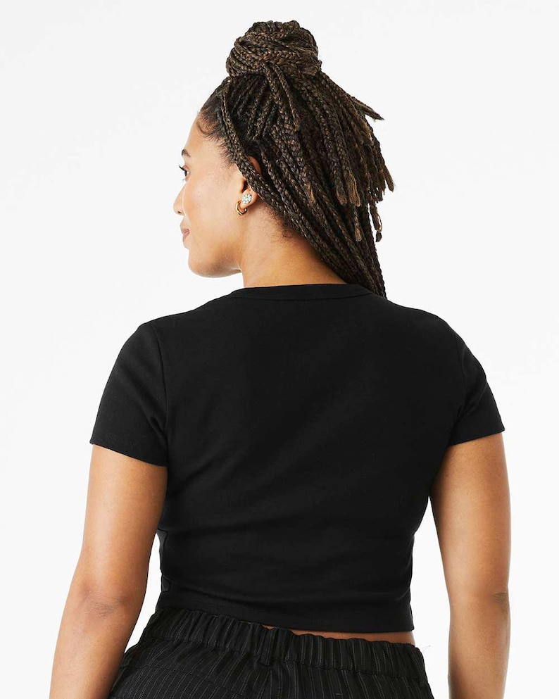 May include: A black cropped t-shirt with short sleeves. The shirt is made of a soft, stretchy fabric and has a relaxed fit.