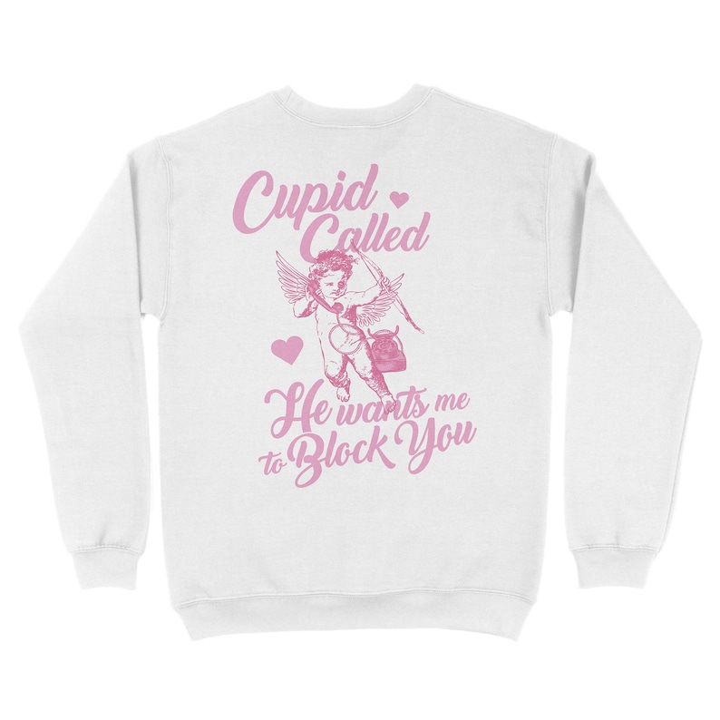 May include: White sweatshirt with a pink graphic of Cupid with an arrow and the text "Cupid Called He wants me to Block You".