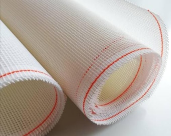 Könnte beinhalten: Gerollter weißer Netzstoff mit roten Nähten an den Kanten. Der Stoff hat ein gitterartiges Muster. Die Rollen sind teilweise abgerollt und zeigen das Innere.