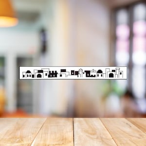 May include: Black and white silhouette of a city skyline with multiple buildings. The skyline is printed on a white background.