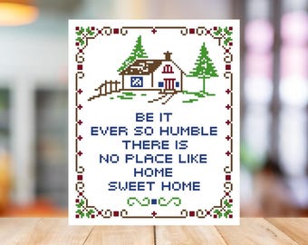 Könnte beinhalten: Ein Kreuzstich-Kunstwerk mit einem Haus und Bäumen, mit dem Text "BE IT EVER SO HUMBLE THERE IS NO PLACE LIKE HOME SWEET HOME" in Blau. Der Rand hat grüne und rote florale Akzente. Das Kunstwerk wird auf einer Holzoberfläche angezeigt.