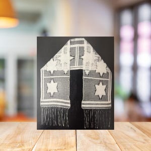 May include: White lace scarf featuring Star of David patterns and fringe. The scarf has a rectangular shape with a central panel and two side panels, each adorned with the star symbol. The edges are finished with delicate fringe.