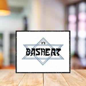 May include: A white card with a blue six-pointed star with the text "It's Bashert" in black.