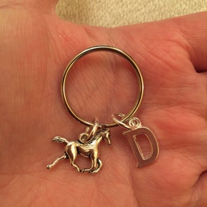 May include: Silver key chain with a horse charm and a letter D charm.
