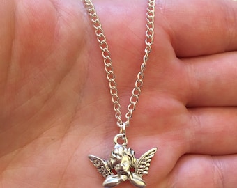 Op de afbeelding: Zilveren ketting met een klein engelbehang. De engel heeft vleugels en kijkt naar beneden.