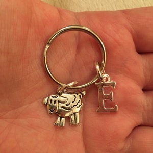 May include: Silver keyring with a small silver sheep charm and a silver letter E charm.