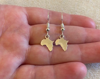 May include: A pair of silver dangle earrings featuring a map of Africa as the charm.
