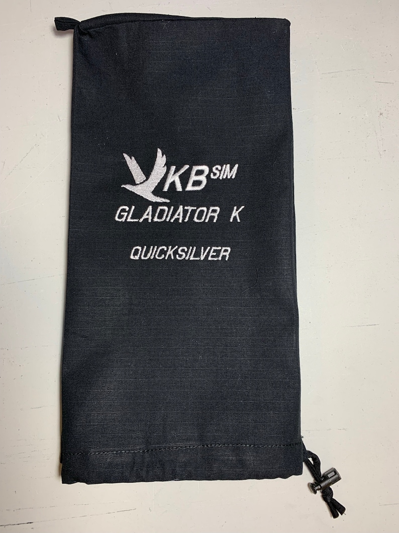 May include: Black drawstring bag with white embroidery. The embroidery includes a stylised bird, the text "KB SIM", "GLADIATOR K", and "QUICKSILVER".