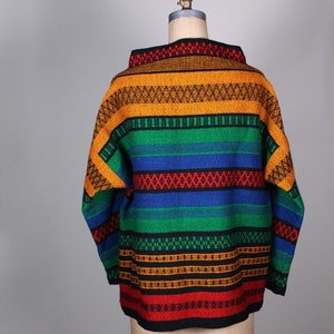May include: A colorful striped sweater with a high neck and long sleeves. The sweater is made of a thick, textured fabric and features a variety of colors, including red, orange, yellow, green, blue, and black.