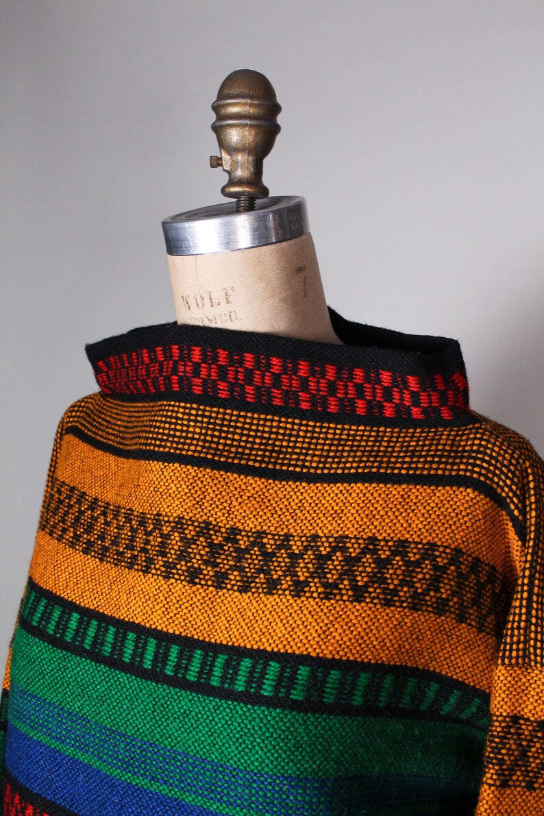May include: A colorful striped sweater with a black mock neck. The sweater has stripes of orange, green, blue, and red.