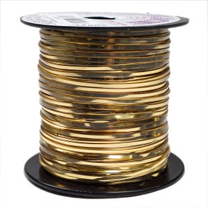 May include: A spool of gold-colored wire, tightly wound and displayed against a white background. The wire is flat and shiny, reflecting light. The spool has a black base and a white label on top. Ideal for jewelry making and crafts.