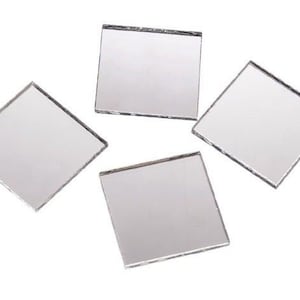 May include: Four small square mirrors with beveled edges. The mirrors are silver and have a reflective surface.