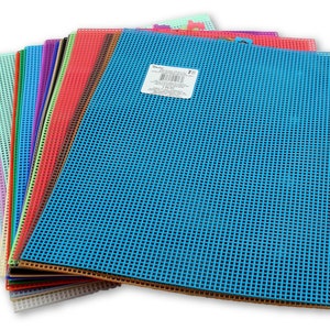 May include: A stack of 18 plastic canvas sheets in various colors, including blue, green, red, orange, yellow, and purple. The sheets are 10 inches by 14 inches and have a 7-count grid.