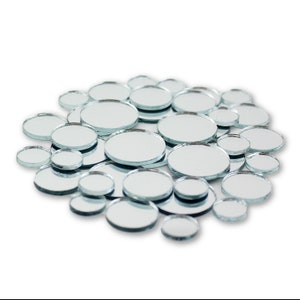 May include: A collection of round, silver-backed mirrors of various sizes. The mirrors are arranged in a loose circle on a white background.