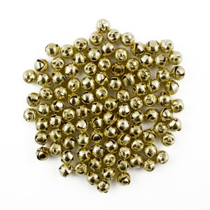 May include: A large pile of gold-colored jingle bells, perfect for adding a festive touch to crafts and decorations.