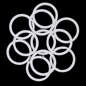 May include: A set of white plastic curtain rings, arranged in a circular pattern.