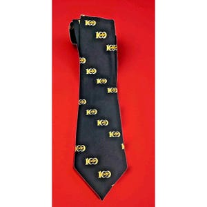 May include: A black necktie featuring a repeating pattern of the number 100 printed in a bright yellow font. The tie has a pointed tip and a smooth, satin-like finish, with the numerical design distributed evenly across the entire fabric surface.