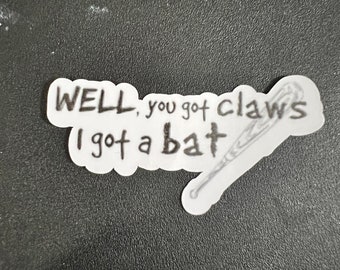 May include: A white sticker with black text that reads "WELL, you got claws I got a bat" with a drawing of a baseball bat.