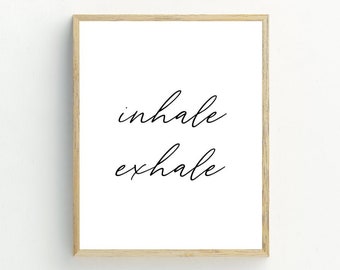 Könnte beinhalten: Ein gerahmter Druck mit den Worten "inhale exhale" in schwarzer Kursivschrift auf weißem Hintergrund.