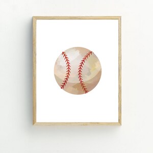 May include: A framed print of a watercolor illustration of a baseball. The baseball is beige with red stitching.