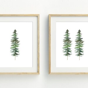 May include: Two framed watercolor paintings of stylized green pine trees. The first painting features a single tree, while the second painting features two trees.