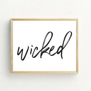 Peut inclure: Une impression encadr&eacute;e avec le mot "wicked" &eacute;crit en cursive noire sur un fond blanc.