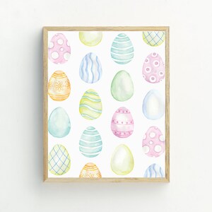 May include: A framed print featuring a pattern of colorful Easter eggs with various designs, including polka dots, stripes, and floral patterns.