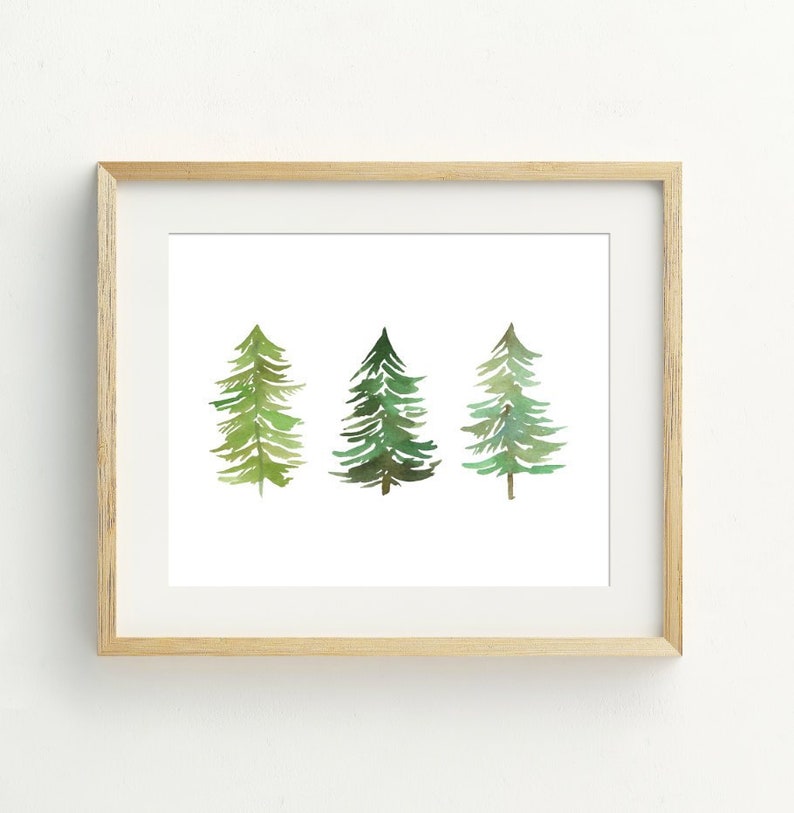 May include: A framed print of three watercolor painted evergreen trees on a white background. The trees are green with shades of yellow and brown.
