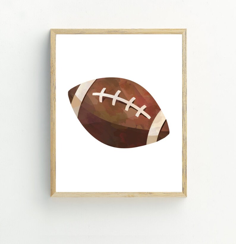 May include: A framed print of a watercolor illustration of a brown football with white laces.