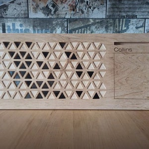 May include: A wooden laptop stand with a geometric pattern and a cutout for a phone or pen. The stand is engraved with the name "Collins".