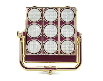 May include: A gold-coloured movie studio light with a red base and nine round, white, gridded lights.