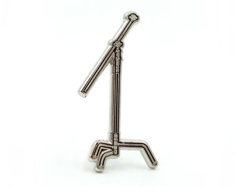 May include: A silver metal light stand with a three-legged base and a telescopic arm.