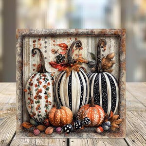 May include: A framed autumn-themed artwork featuring three decorative pumpkins. The pumpkins are white with floral and striped patterns, and orange with polka dots. The artwork includes fall leaves and berries.