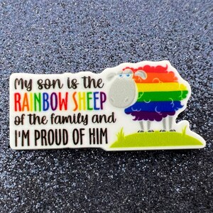 May include: A white background with the text "My son is the RAINBOW SHEEP of the family and I'M PROUD OF HIM". A cartoon sheep with a rainbow colored wool coat is standing on a green patch of grass.