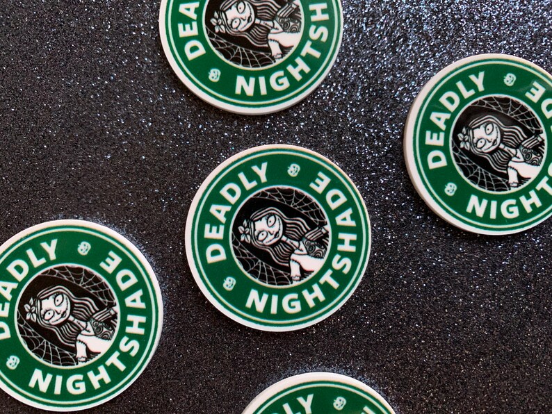 Puede incluir: Cuatro pegatinas redondas verdes y blancas con el texto "Deadly Nightshade" y una imagen de dibujos animados de una ni&ntilde;a con cabello negro y un vestido blanco. Las pegatinas tienen un dise&ntilde;o de telara&ntilde;a.