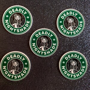 Puede incluir: Cinco pegatinas redondas verdes y blancas con el texto "DEADLY NIGHTSHADE" y una ilustraci&oacute;n en blanco y negro de una mujer con una corona de flores.