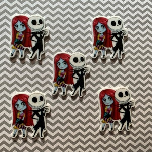 Puede incluir: Cinco pegatinas de personajes de dibujos animados coloridos con Jack Skellington y Sally de la pel&iacute;cula Pesadilla antes de Navidad. Las pegatinas est&aacute;n sobre un fondo de patr&oacute;n de chevron gris y blanco.