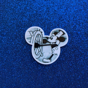 May include: Black and white illustration of Mickey Mouse as a steamboat captain, steering a ship's wheel. The image is in the shape of Mickey Mouse's head.